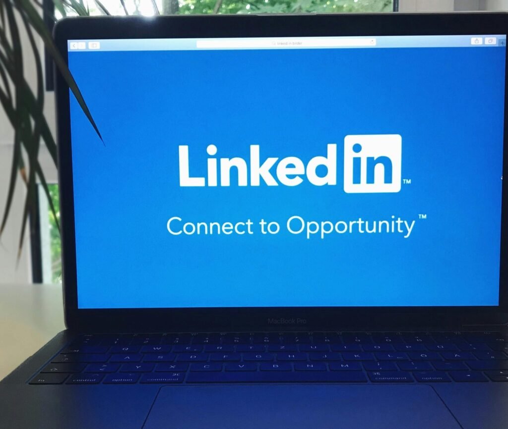 A laptop screen displaying the LinkedIn logo with the text 'Connect to Opportunity'.