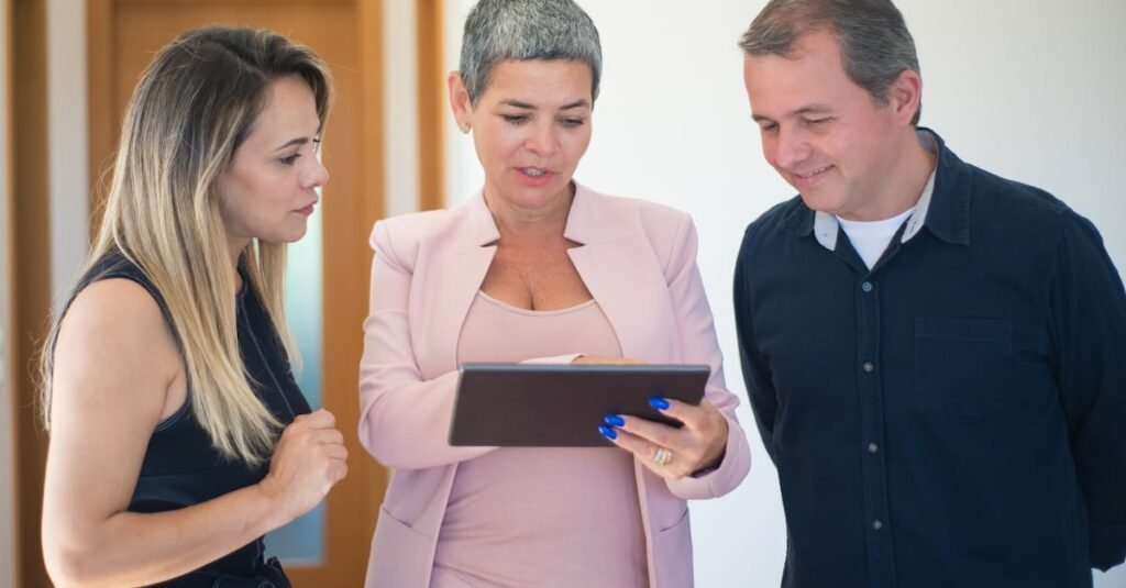 Real estate agent presenting property details to a couple using a tablet indoors.